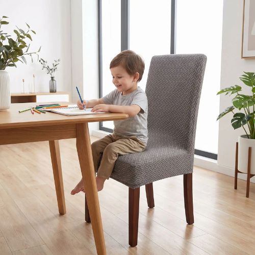 Enfant assis sur une chaise avec une housse de chaise